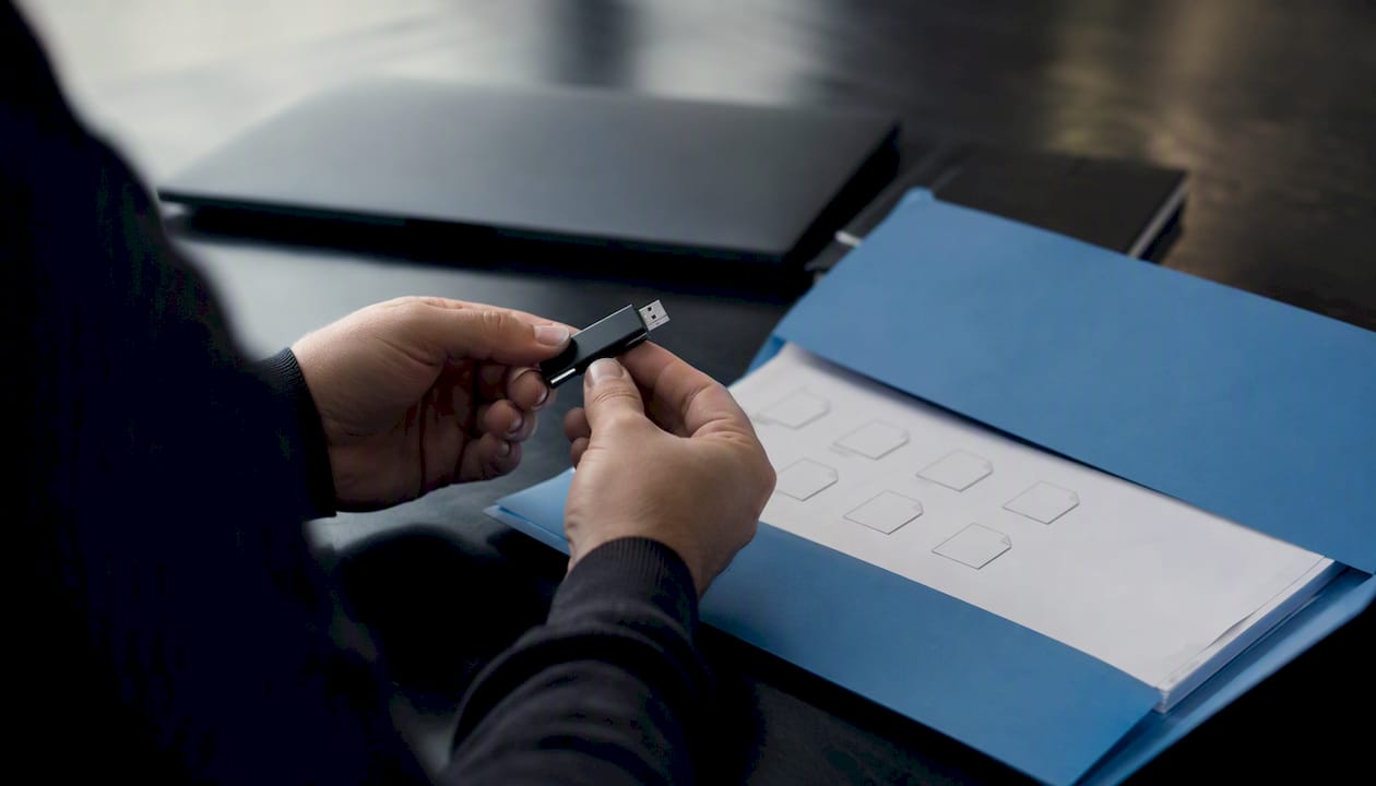 Hands holding storage device near XML files folder